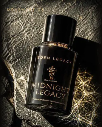 Midnight Legacy Extrait de Parfum by Eden Legacy, a bottle angled on rough stone beside fine golden strands.